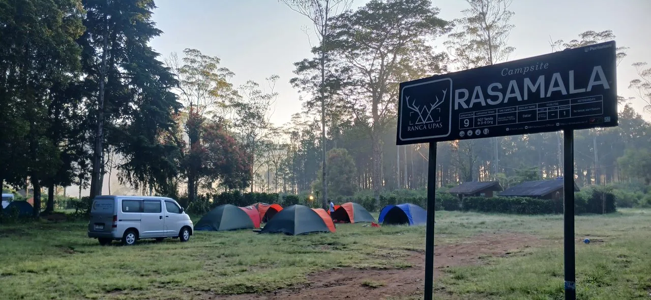 Papan Campsite Rasamala di antara tenda saat pagi berkabut